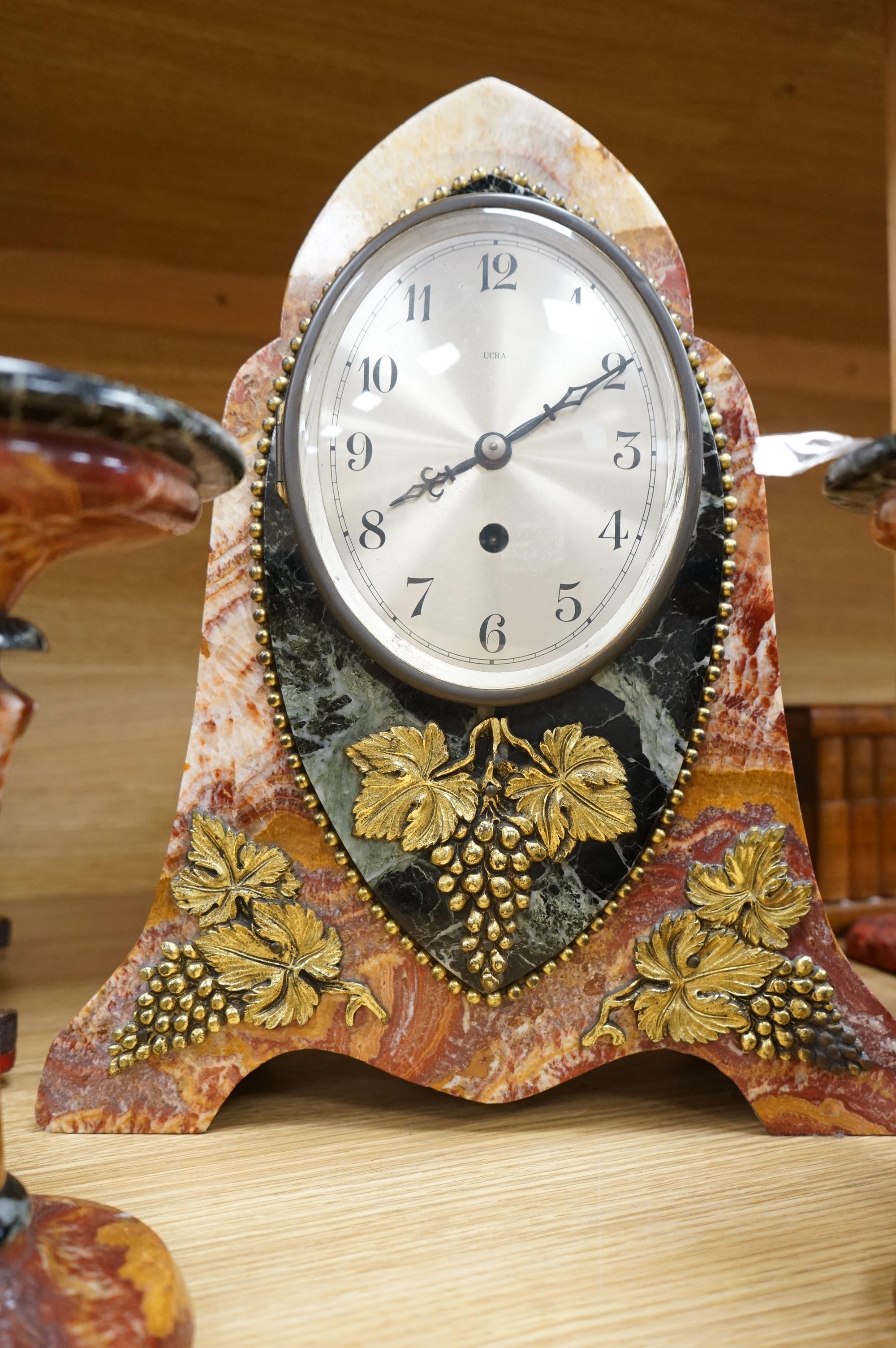 An early 20th century French rouge and black marble clock garniture with ornamental grape motif mounts to the clock and with a key, clock 34.5cm high